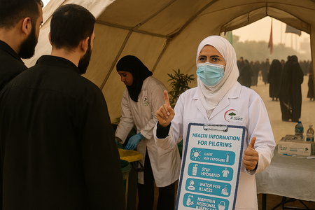 Health worker holding health recommendations for pilgrims. Credit: Iraq Ministry of Health